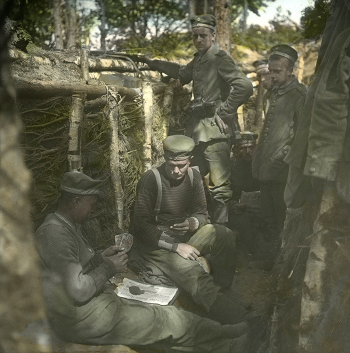 Des soldats allemands jouent aux cartes dans une tranchée.
